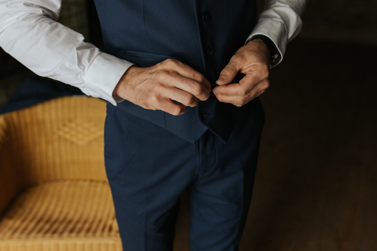 détail habillage préparatifs mariés costume bleu veston
